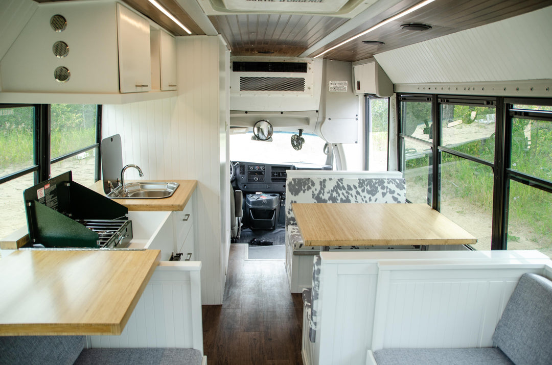 modern beach house style transit bus conversion with wood accents and custom cow print cushions