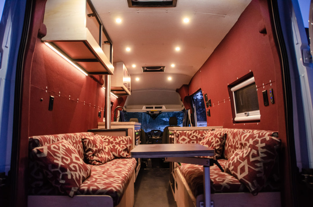 Interior of a red ford transit van conversion with unique cushions