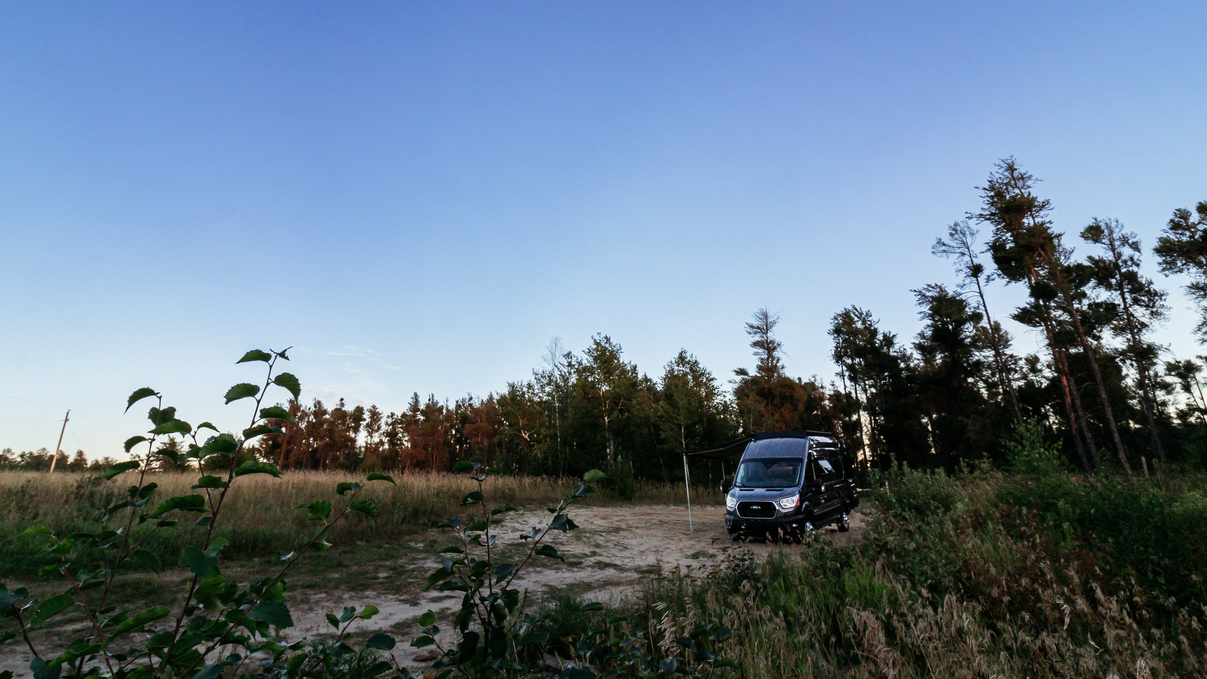 transit camper vans sitting in a field camping