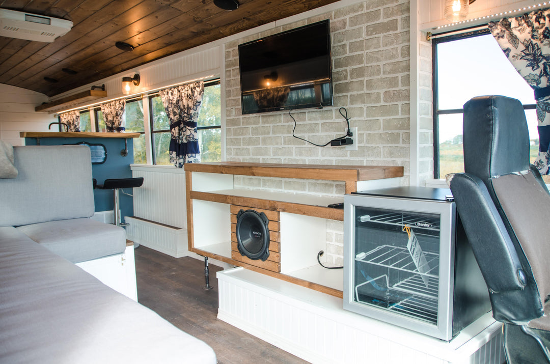 modern farmhouse school bus with a brick accent wall with a TV and entertainment unit